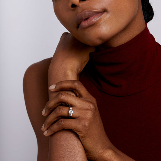 Model wearing Trilogy Cushion cut engagement ring in platinum