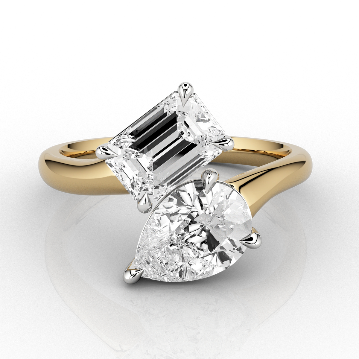 A toi & moi ring featuring a pear and emerald-cut diamond set in 18ct yellow gold, with a clear andPrincess-cut diamond set in a separate band.